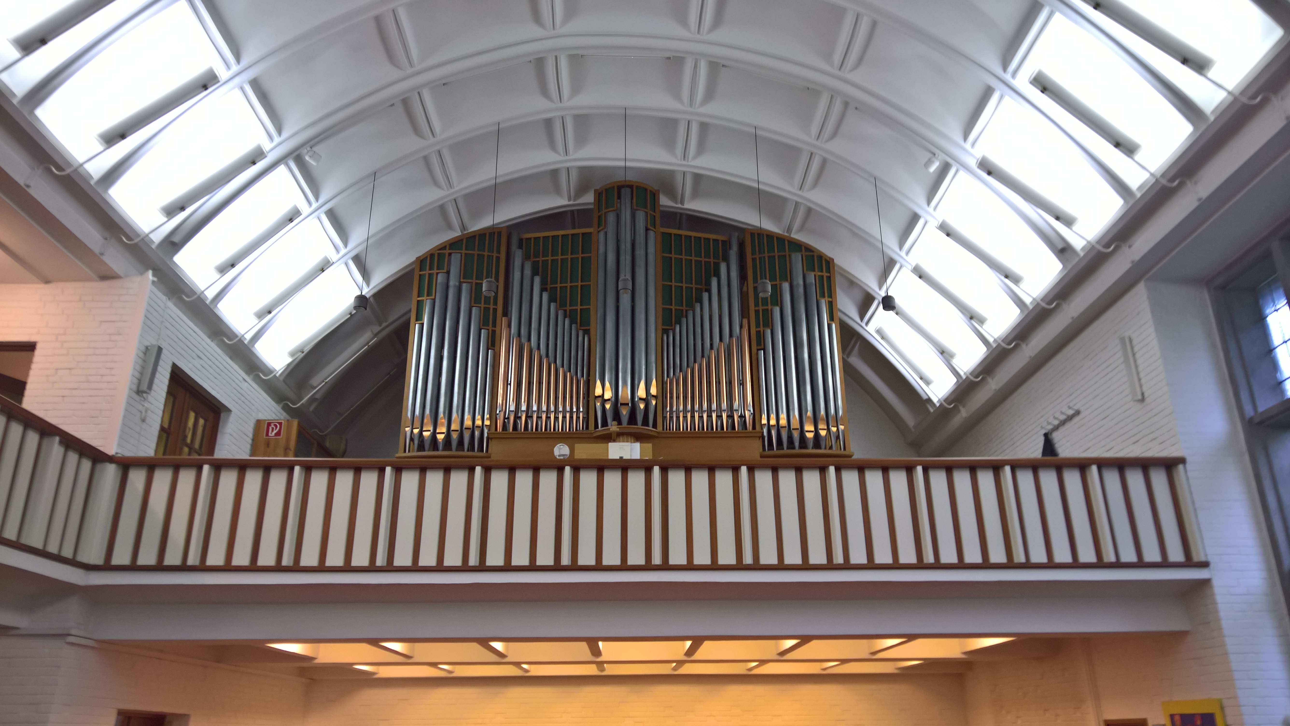 Ein Foto der Orgel in der Auferstehungskirche, aufgenommen von unten im Kirchraum mit der Perspektive nach oben auf die Orgel.