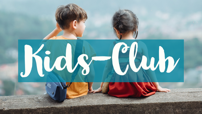 Ein Bild von 2 Kindern. Sie tragen ein orangenes T-shirt und ein rotes Kleid und sitzen auf einer grauen Mauer. Die Kinder sind nur von hinten zu sehen.